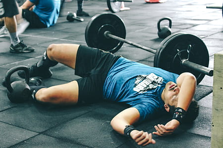 Man Lying on Rubber Mat Near Barbell Inside the Gym thumbnail
