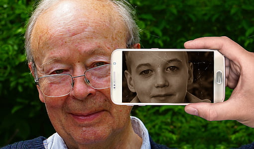 person holding phone beside man with photo thumbnail