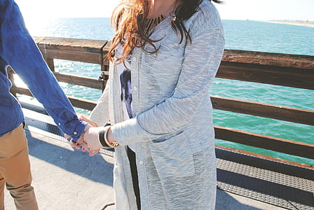 woman standing beside person while holding hands at daytime thumbnail