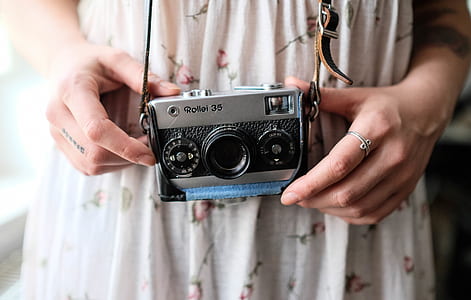 woman holding silver SLR camera thumbnail