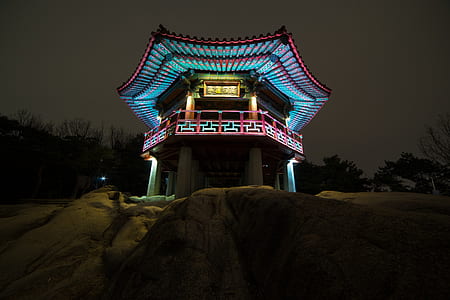 blue lighted temple on rocky mountain taken during night time thumbnail