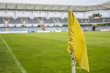 yellow flag in the middle of green grassy field thumbnail