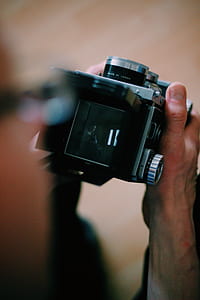 person holding black digital camera thumbnail