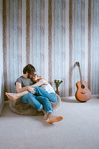 man and woman sitting on beanbag chair while looking at each other inside room thumbnail