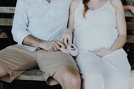 man sitting beside woman holding pair of shoes thumbnail
