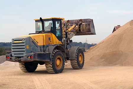 yellow front loader fronting pile of sand thumbnail
