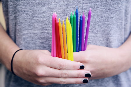 person holding assorted-color candles thumbnail