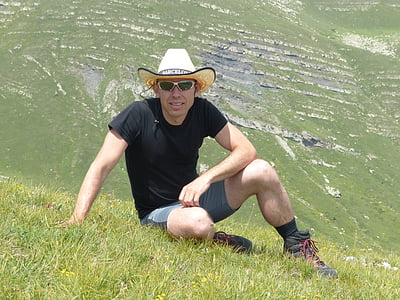 man sitting on green grass during daytime thumbnail