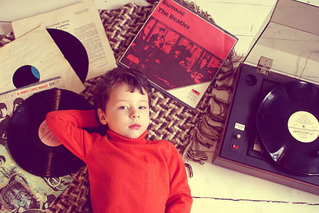 boy's laying on black vinyl record thumbnail