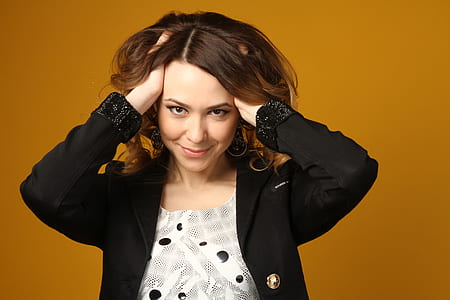 woman wearing black blazer holding her hair thumbnail