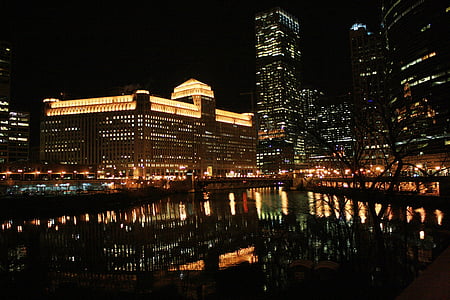 brown concrete building beside river thumbnail