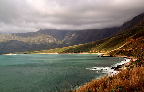 landscape photography of seashore beside mountaints thumbnail