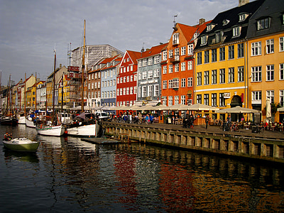 boats beside yellow and orange building at daytime thumbnail