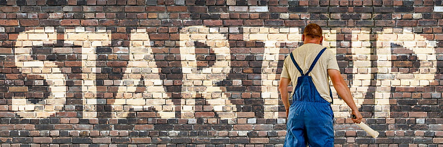 man painting startup text on wall thumbnail
