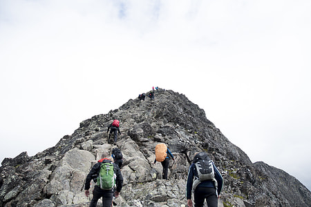 group of people hiking on gray mountain under white sky thumbnail