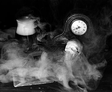 grayscale photography of mantle clock and human skull thumbnail
