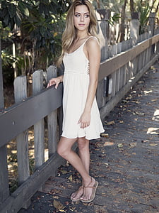 woman standing beside gray wooden fence thumbnail