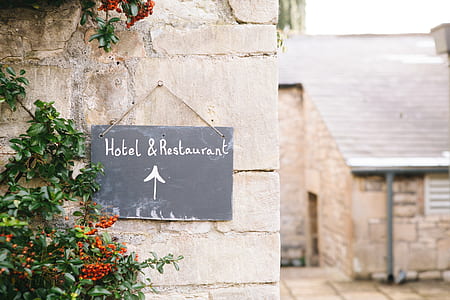 hotel and restaurant signboard on wall near plant thumbnail