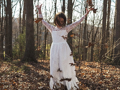 woman raising hands standing under shade of trees during daytime thumbnail
