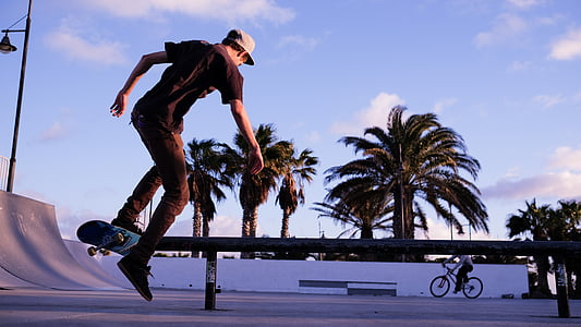 man skating on pathway near another person thumbnail