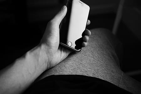 grayscale photo of person holding iPhone thumbnail