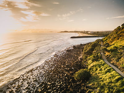 landscape photography of a roadway near body of water thumbnail