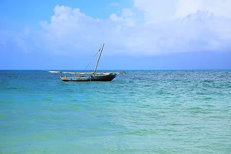 brown and blue wooden boat on body of water during daytime thumbnail