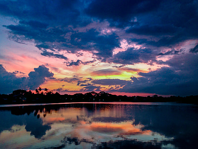 body of water under blue and orange sky during daytimne thumbnail