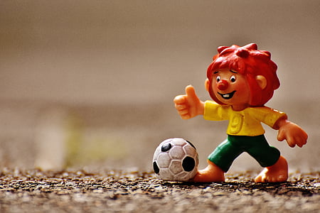 plastic soccer player figure on brown surface thumbnail
