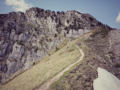 person hiking on hill under blue sky thumbnail