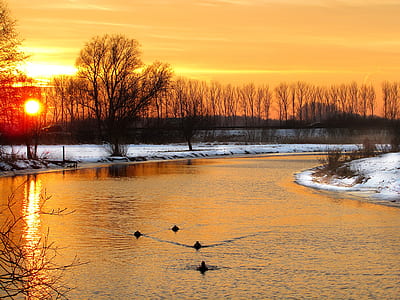 snow field near river during sunset thumbnail