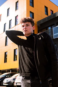 man standing in front of building holding his jacket thumbnail