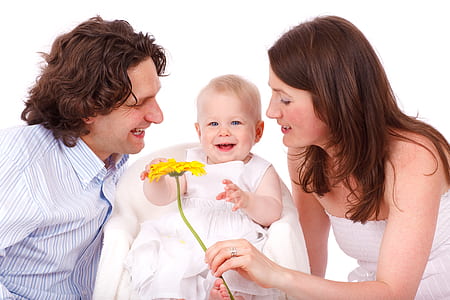 woman holding yellow Gerbera flower beside girl wearing white crew-neck sleeveless a-line dress thumbnail