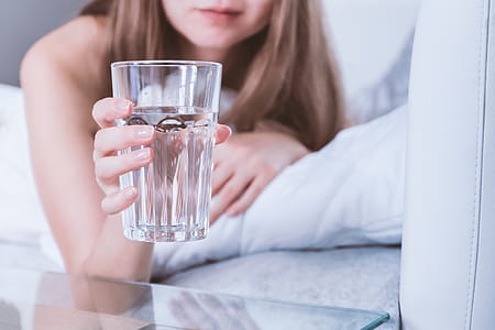 Close up Woman holding glass of water on bed in the morning thumbnail