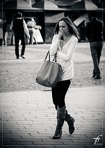 grayscale photo on woman walking on brick floor thumbnail