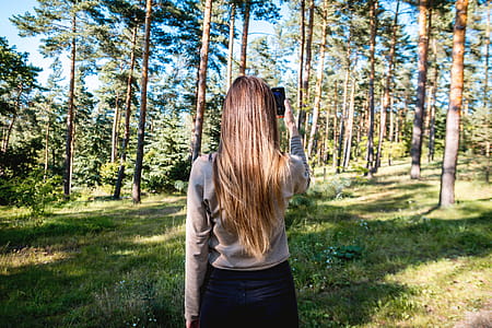 Beauty brunette girl make photo with her smartphone in the forest thumbnail