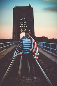 man standing on railway with U.S.A. flag thumbnail