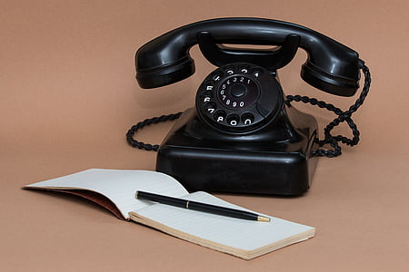 black rotary phone near notebook and pen thumbnail