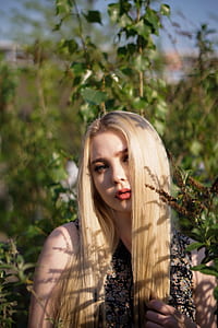 woman standing near green leaf plant during daytime thumbnail