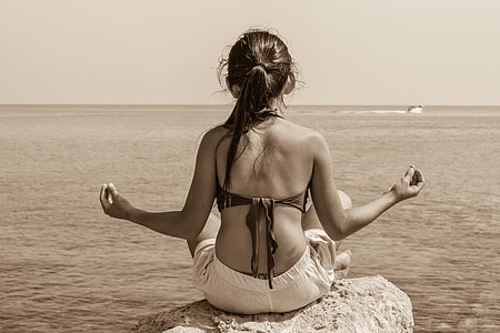 meditating woman sitting on rock thumbnail