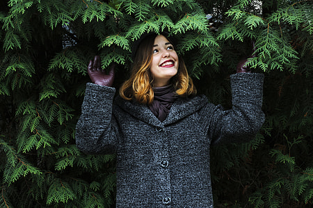 woman smiling and looking upward at plants thumbnail