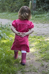 girl wearing pink dress standing near trees thumbnail