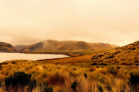 landscape photography of brown mountain near body of water thumbnail