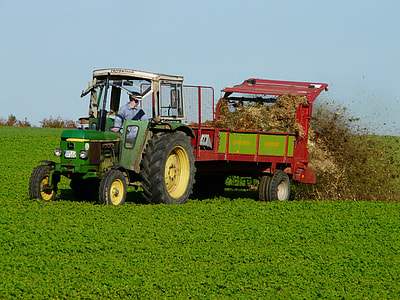 person riding on farm tractor throwing soil on field thumbnail