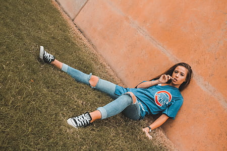 woman lying on grass leaning on brown wall thumbnail