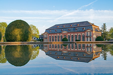 red building near body of water and topiary thumbnail