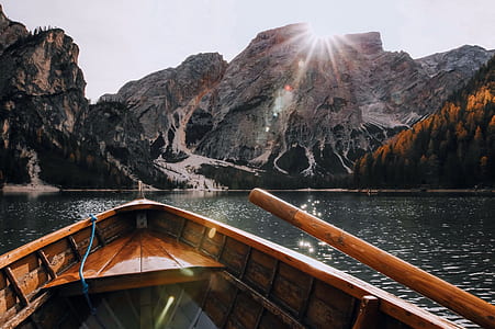 Brown Canoe in the Body of Water Near Mountain thumbnail