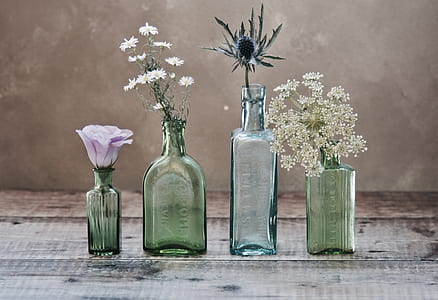 four glass vase with flowers on wooden panel thumbnail