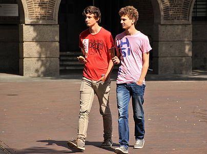 two men walking in front of building during daytime thumbnail