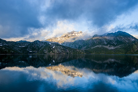 snow capped mountain near body of water under blue cloudy sky thumbnail